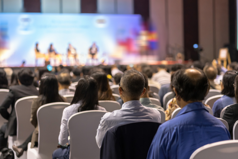 Conference audience watching a live panel discussion on stage